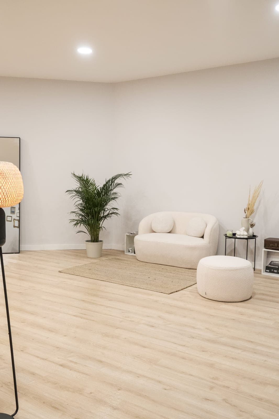A sala principal do atelier, com sofá claro, planta e luz suave