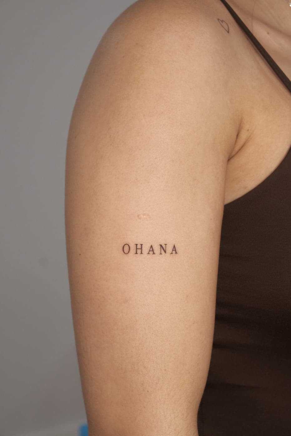Palavra «ohana» em letras espaçadas no braço
