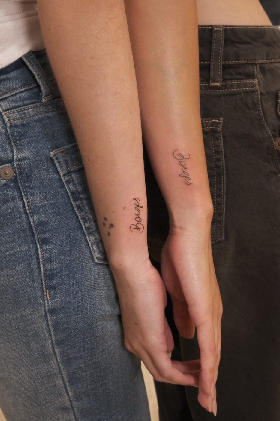 Duas pessoas com tatuagens a condizer nos antebraços